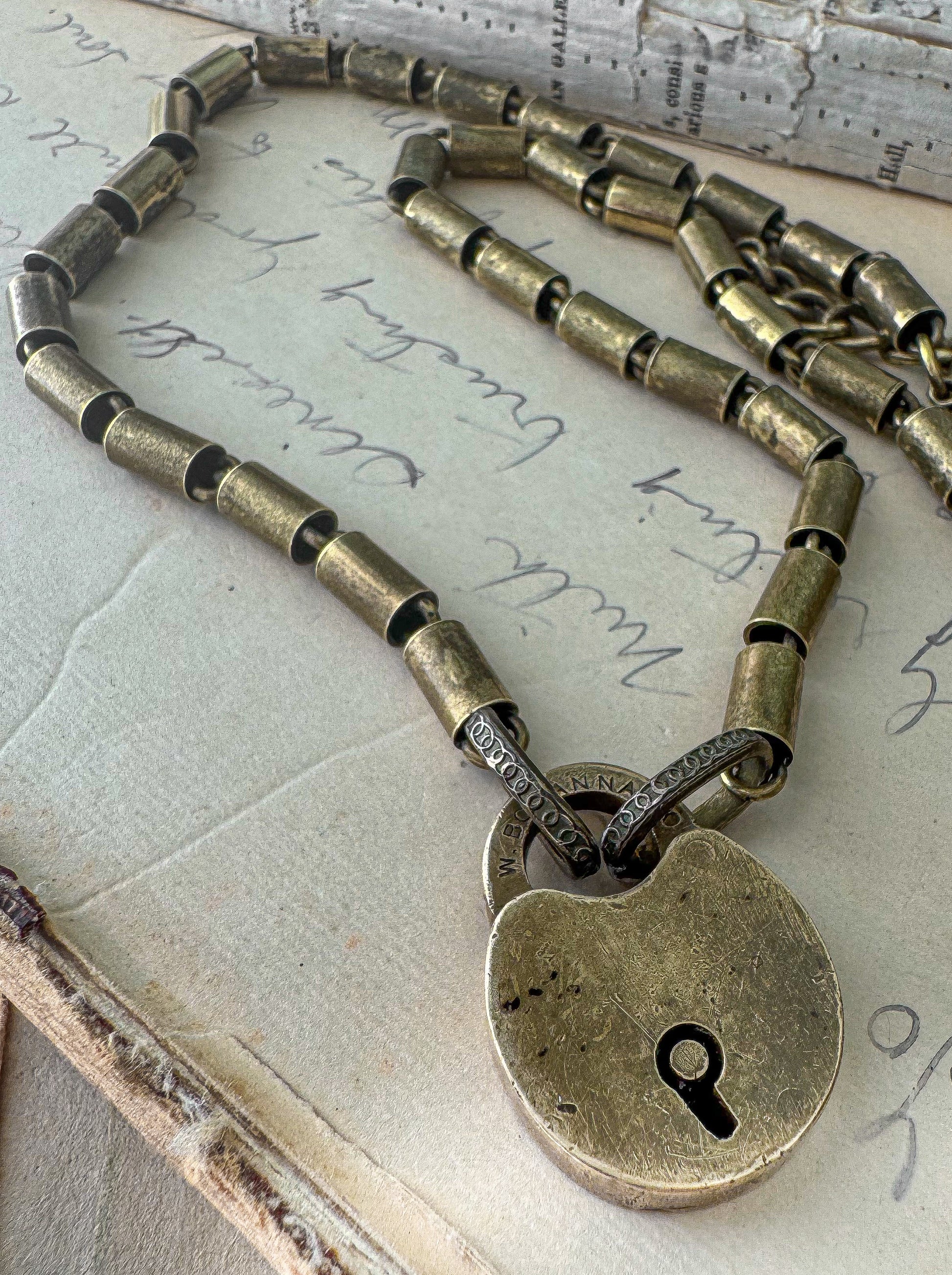 Bronze padlock necklace on an old letter